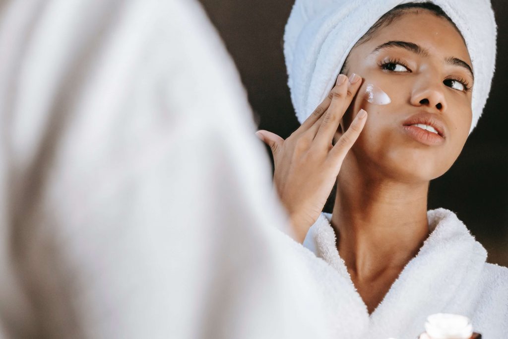 woman applying cream to her face