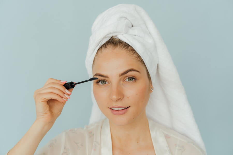 woman applying makeup to her face