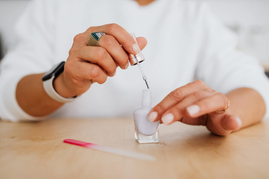 woman painting nails and waiting for them to dry