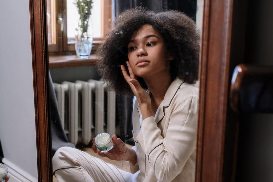 woman applying green beauty skincare product