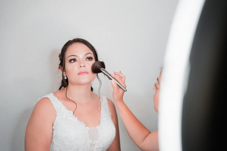 a bride having her makeup done by an artist who is training for how to become a makeup artist