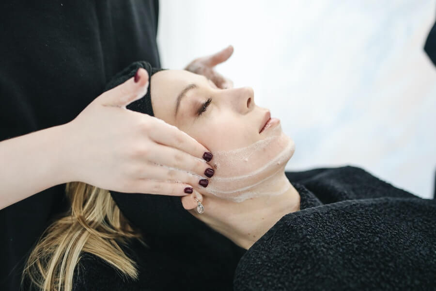 an esthetician preparing a client for a facial treatment