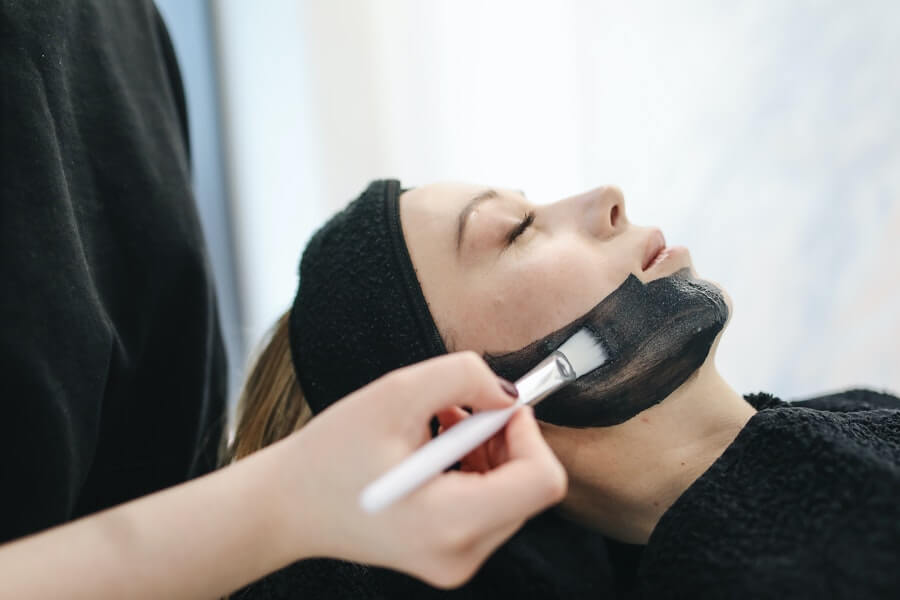 an esthetician applying facial treatment to client