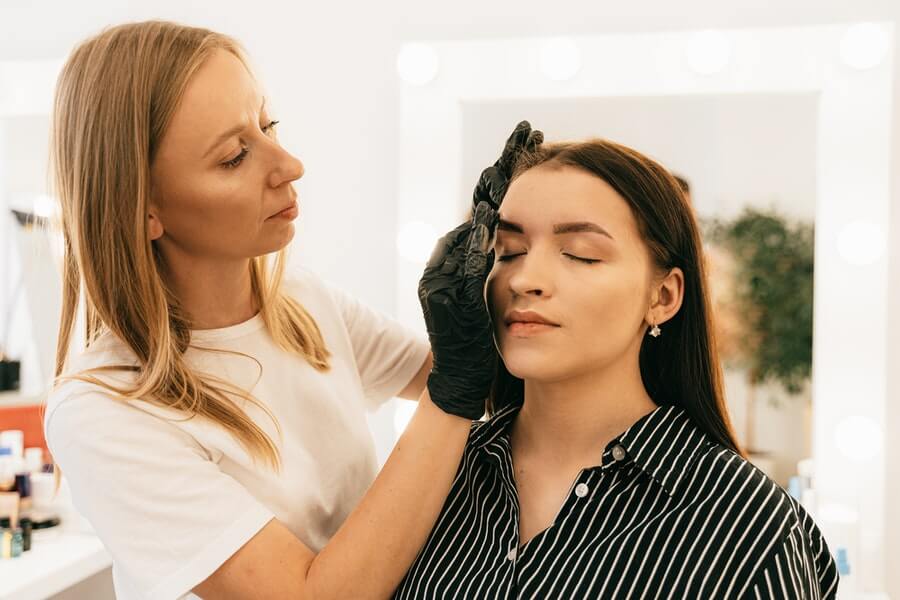 a makeup artist applying makeup to their client