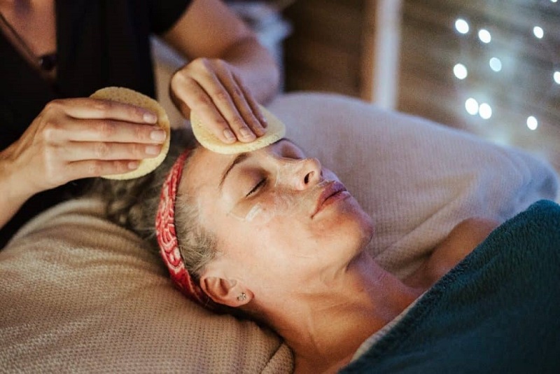 A beauty therapist carrying out a beauty facial massage on a patient