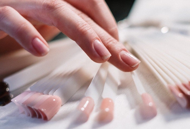 Woman picking out of a selection of fake nails